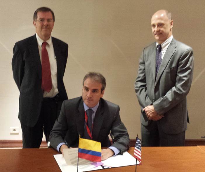 Pablo Felipe Robledo (seated), Colombia’s Superintendent of Industry and Commerce, signs the MOU with Russell Damtoft, Associate Director, FTC Office of International Affairs and Caldwell Harrop, Dept. of Justice looking on.